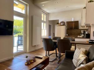 a kitchen and living room with a table and chairs at Villa Anna - Kaiserperle in Heringsdorf