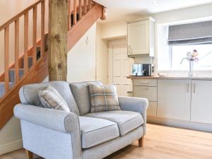 ein Wohnzimmer mit einem Stuhl und eine Küche in der Unterkunft High Dale Cottage in Bellerby