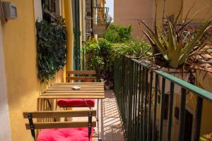 2 sedie e un tavolo sul balcone con piante di Badia Holiday Home a Taormina