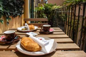 un tavolo con due piatti di pane e tazze di caffè di Badia Holiday Home a Taormina