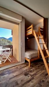 sypialnia z łóżkiem piętrowym i balkonem w obiekcie Studio Le Banga d'Ax w mieście Ax-les-Thermes