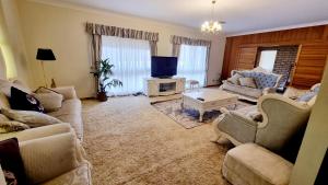 a living room with two couches and a tv at Spacious Holiday Home - Waikerie in Waikerie