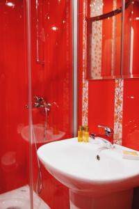 a red bathroom with a sink and a shower at Borovets Green Hotel in Borovets