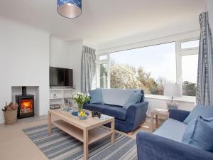 a living room with a blue couch and a fireplace at Blue Horizon in Sidmouth