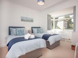 a bedroom with two beds and a window at Blue Horizon in Sidmouth