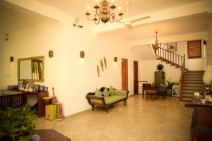a living room with a chandelier and a couch at Kingfisher Bamboo Garden Villa in Unawatuna