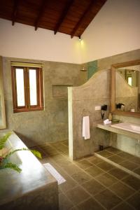 a bathroom with a sink and a mirror at Kingfisher Bamboo Garden Villa in Unawatuna