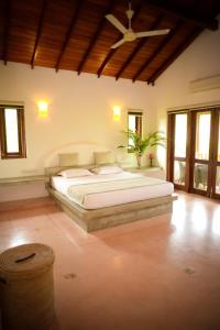 a bedroom with a large bed in a room with windows at Kingfisher Bamboo Garden Villa in Unawatuna