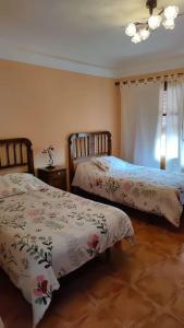 1 dormitorio con 2 camas y ventana en Casa rural completa LA CRIVA 11pers, en Crivillén
