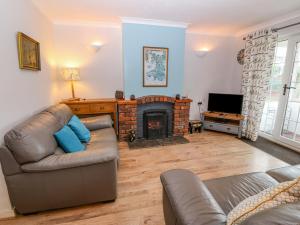a living room with a couch and a fireplace at Stepping Stones 1 in Pwllheli