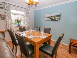 a dining room with a wooden table and chairs at Stepping Stones 1 in Pwllheli