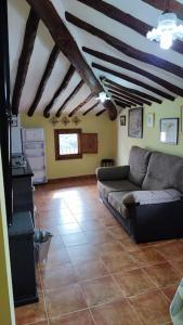 sala de estar con sofá en el suelo de baldosa en Casa rural completa LA CRIVA 11pers, en Crivillén