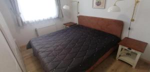 ヴェスターラントにあるSylter-Besserburg-App-13のベッドルーム1室(黒い掛け布団、窓付)