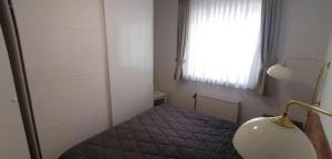 ヴェスターラントにあるSylter-Besserburg-App-13の窓の前にベッドが備わる小さな客室です。