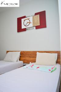 dos camas sentadas una al lado de la otra en una habitación en Hotel Victor, en Patos de Minas