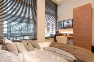 a bedroom with a bed and a desk and windows at Novallure City Centre in The Hague