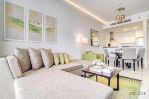 a living room with a couch and a dining room at Urban 1BR at DAMAC Celestia B Dubai South by Deluxe Holiday Homes in Dubai