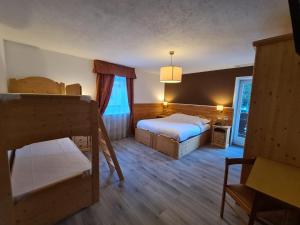 Postel nebo postele na pokoji v ubytování Hotel Rododendro Val di Fassa