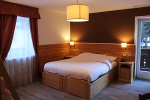Postel nebo postele na pokoji v ubytování Hotel Rododendro Val di Fassa
