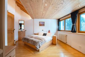 - une chambre avec un lit et un plafond en bois dans l'établissement Mountain Living Apartment Idylia, à Ortisei