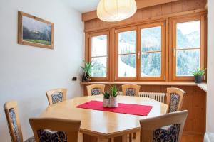 - une salle à manger avec une table et des chaises en bois dans l'établissement Mountain Living Apartment Idylia, à Ortisei