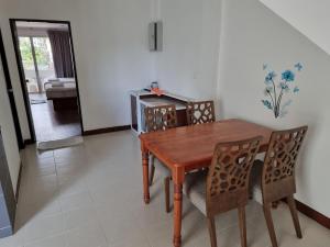 a dining room with a wooden table and chairs at Jinta Andaman in Kata Beach