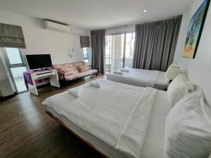 Habitación de hotel con 2 camas y TV en Jinta Andaman, en Kata Beach