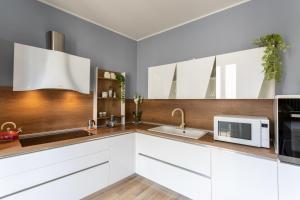 a kitchen with white cabinets and a microwave at Arona Luxury house 50 mt from lake in Arona