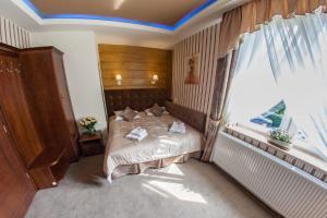 a bedroom with a bed and a large window at Hotel Fryderyk in Rzeszów