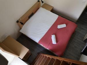 um quarto com uma cama com uma cadeira vermelha em Allenby2 B&B em Jerusalém