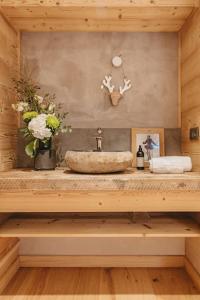 La salle de bains est pourvue d'un lavabo et de fleurs sur un comptoir. dans l'établissement Chalet Isabella : cozy & comfy in central Chamonix, à Chamonix-Mont-Blanc