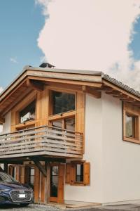 a house with a balcony and a car parked in front of it at Chalet Isabella : cozy & comfy in central Chamonix in Chamonix