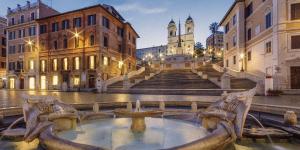 a building with a fountain in the middle of a street at Hotel Nizza in Rome