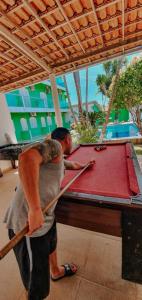 a man and a woman standing next to a pool table at Pousada Terra Nostra in Prado