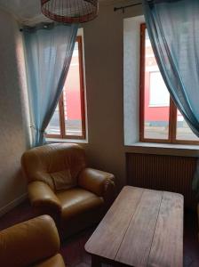 a living room with a couch and a table and windows at Maison de vacances à Cayeux-sur-Mer in Cayeux-sur-Mer