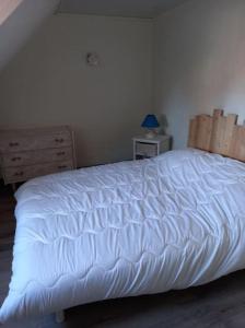 a bedroom with a white bed and a dresser at Maison de vacances à Cayeux-sur-Mer in Cayeux-sur-Mer