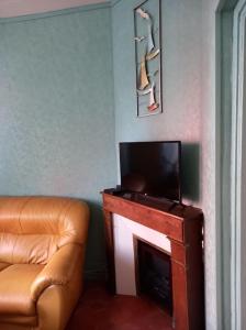 a living room with a couch and a television at Maison de vacances à Cayeux-sur-Mer in Cayeux-sur-Mer