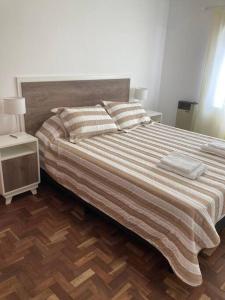 1 dormitorio con 1 cama grande y suelo de madera en Excelente dpto. en Alta Córdoba en Córdoba