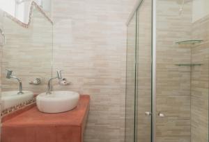 uma casa de banho com 2 lavatórios e uma cabina de duche em vidro. em Pousada Vila Bacana em São Miguel do Gostoso