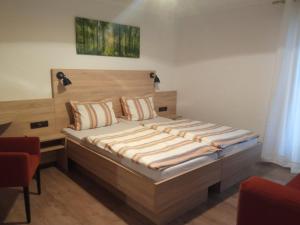 a bedroom with a large bed with a wooden headboard at Gasthof Zum Löwen in Mespelbrunn