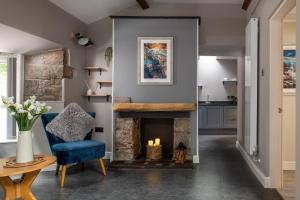 a living room with a blue chair and a fireplace at Bryntirion Lodge in Y Felinheli