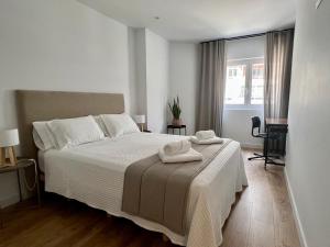 ein Schlafzimmer mit einem Bett mit zwei Handtüchern darauf in der Unterkunft Piso Exclusivo en Vigo céntrico, negocios, confort in Vigo