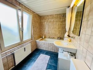 baño con lavabo, bañera y ventana en Newly furnished beautiful old building apartment in the center with Apple TV O1, en St. Gallen