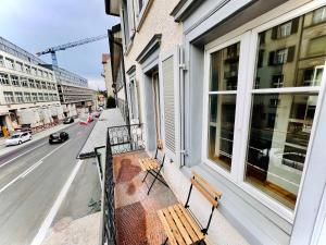 two benches on the balcony of a building at Newly furnished beautiful old building apartment in the center with Apple TV O1 in St. Gallen