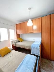 Cette petite chambre comprend 2 lits et une armoire. dans l'établissement Cosy apartment near the beach, à Arinaga