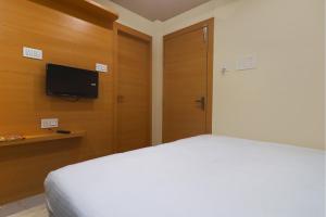 a bedroom with a bed and a flat screen tv at FabExpress Ganpati 2 in Siliguri