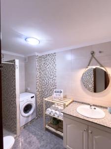 ein Badezimmer mit einem Waschbecken und einer Waschmaschine in der Unterkunft Cosy apartment near the beach in Arinaga