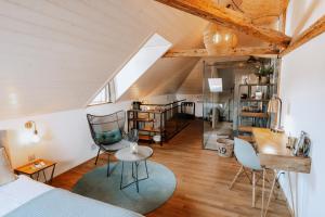 a bedroom with a bed and chairs in a attic at Zimmerei in Murten