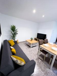 a living room with a couch and a table at Cosy apartment near the beach in Arinaga +18 photos