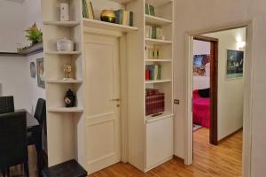 a room with a door and shelves with books at Arezzo Charming Apartment in Arezzo